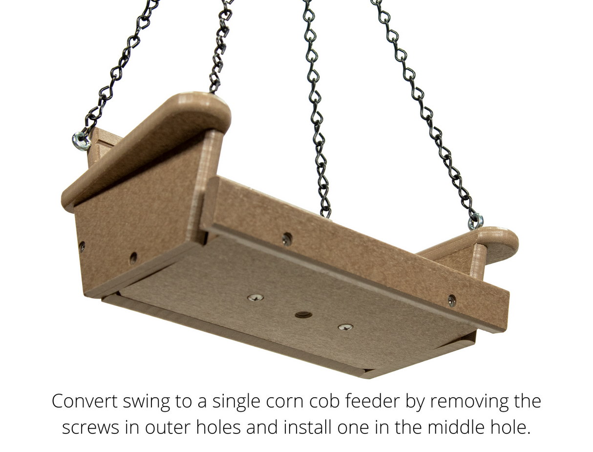 Product photography of a tan plastic single corn cob feeder hanging from black chains showing visible screws and a flat platform design