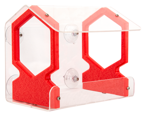 Acrylic and plastic bird feeder with red accents and suction cups showing a house-shaped design against a white background
