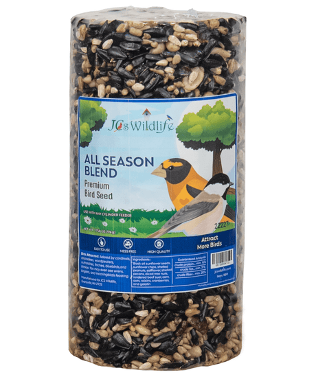 JCS Wildlife's All Season Blend premium bird seed cylindrical package shows black oil sunflower seeds, shelled peanuts, and colorful cranberries against a background featuring a cardinal and chickadee near a tree
