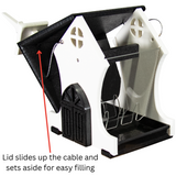 Plastic bird feeder with removable lid, featuring a house-like design with black trim, arched door, and cross-shaped window details showcasing easy filling mechanism
