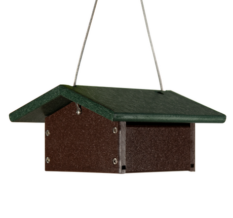 Recycled plastic bird feeder showing a dark brown body and a green pitched roof hanging from a silver wire.
