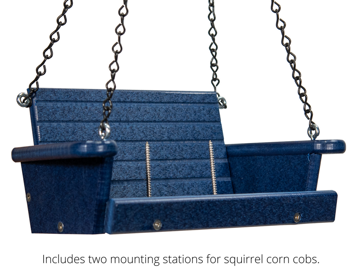 Product shot of a dark blue plastic squirrel feeder swing with black chains and silver screws showing two mounting stations for corn cobs
