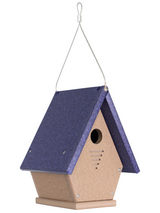 Recycled plastic birdhouse with a dark purple roof and tan body hanging from a wire against a white background featuring a round entrance hole and ventilation slits