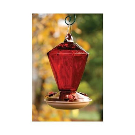 Copper Color Hummingbird Feeder with Ruby Diamond Glass and 24oz nectar capacity hanging in a garden with a blurred background.