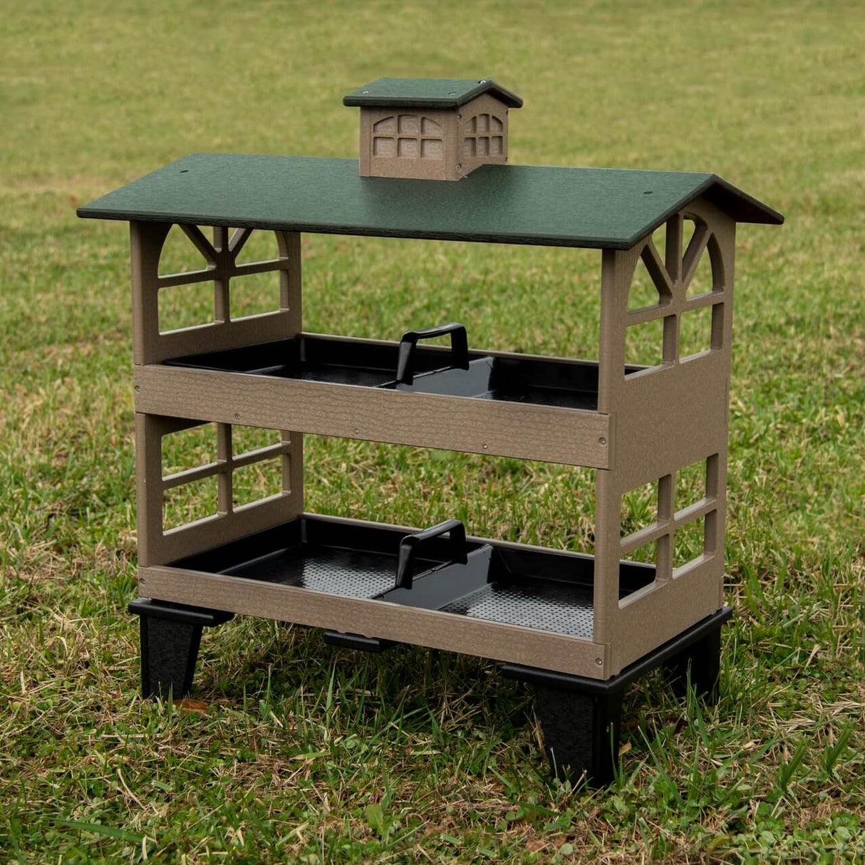 JCS Wildlife Double Colossal Ground Fly Thru Bird Feeder with spacious trays for birds in a grassy area.