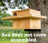 JCS Wildlife Large Barn Owl Box with Exercise Platform mounted on a tree, labeled 'Box does not come assembled'.
