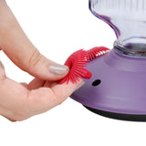 Close-up of a hand removing the flower-shaped feeding port on the Perky-Pet Lavender Field Top-Fill Glass Hummingbird Feeder for cleaning.